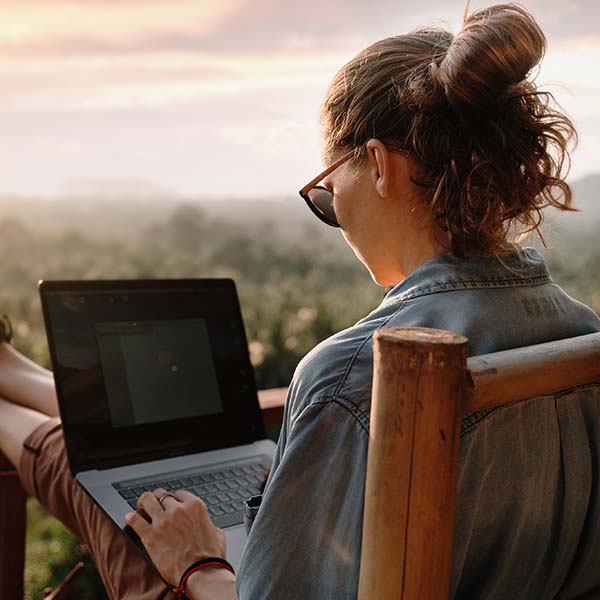 Young business woman working at the computer in cafe on the rock